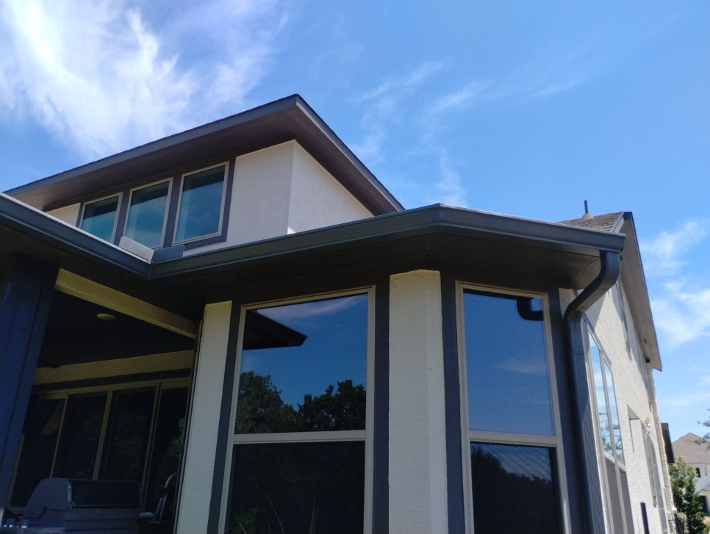 Gutter and downspout along a stucco bay in New Braunfels
