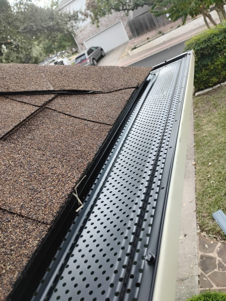 Close-up of a clean metal gutter system along asphalt shingles in Lakewood