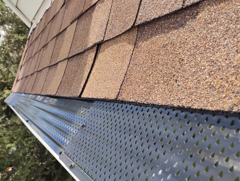 Roof edge detail showing winter gutter protection on an Englewood home