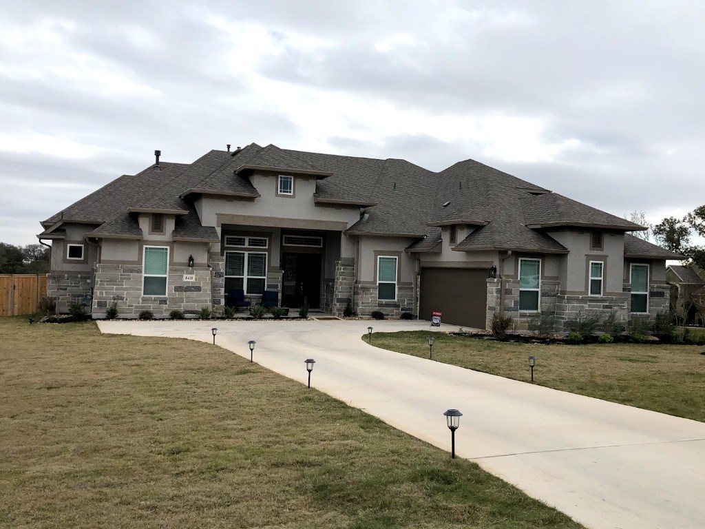 Stone and stucco home with seamless gutters in Bulverde